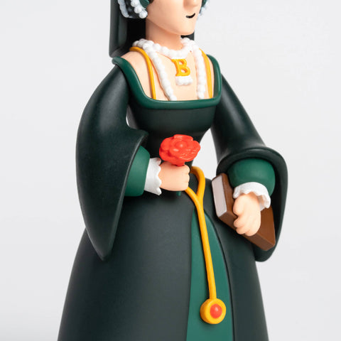 Figurine of Anne Boleyn in traditional attire holding a red flower and a book on a white background